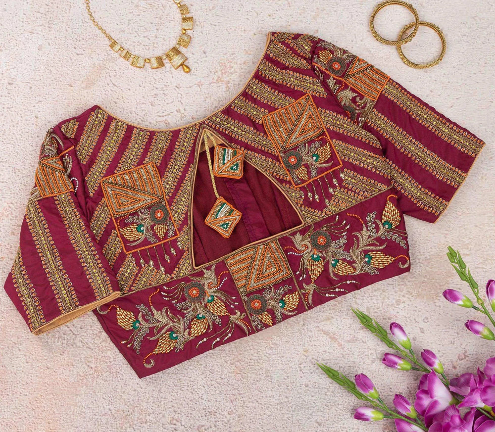 Flat-lay of gold striped and floral embroidery with triangle patches on wine maroon