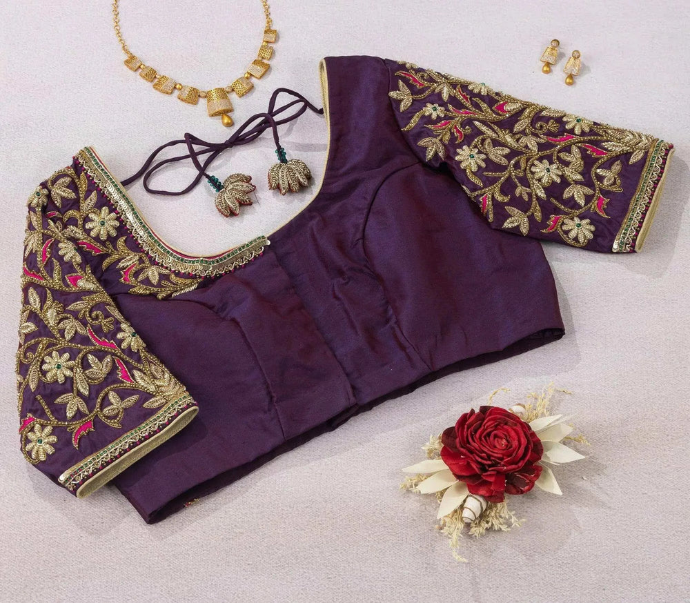 Plain purple bodice front with heavily embroidered sleeves, flat-lay with gold necklace and jhumkas