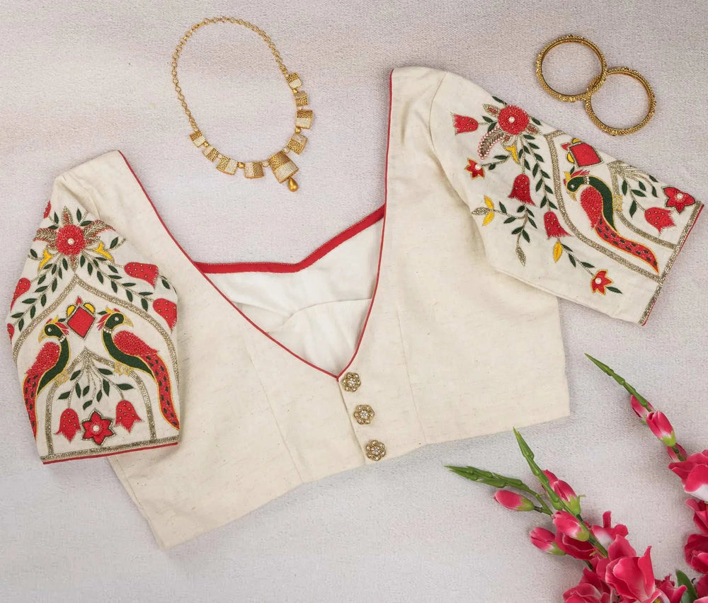 Ivory blouse flat-lay showing button back and embroidered sleeves, with gold necklace and bangles