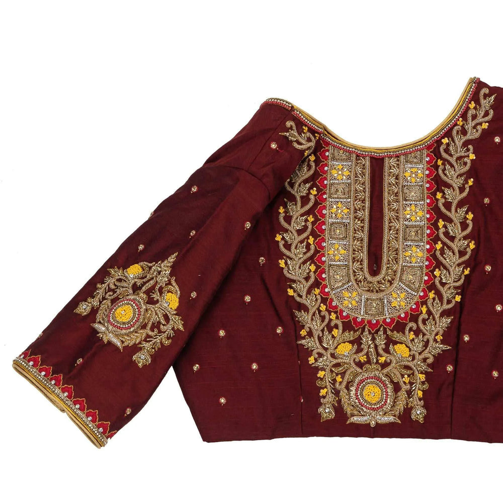 Close-up of gold and yellow zardozi work on the maroon blouse panel and sleeve