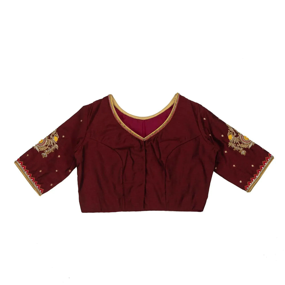 Plain panel of the maroon blouse photographed flat against white, V neck and gold piping