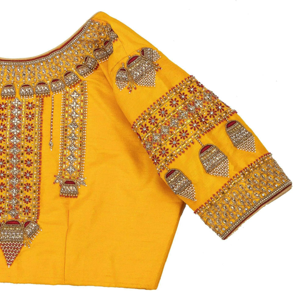 Close-up of jhumka motifs and mirror work across the shoulder and sleeve band
