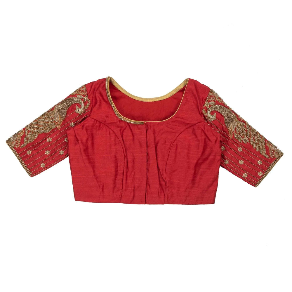 Front of the red blouse laid flat, gold-piped neckline and embroidered sleeves