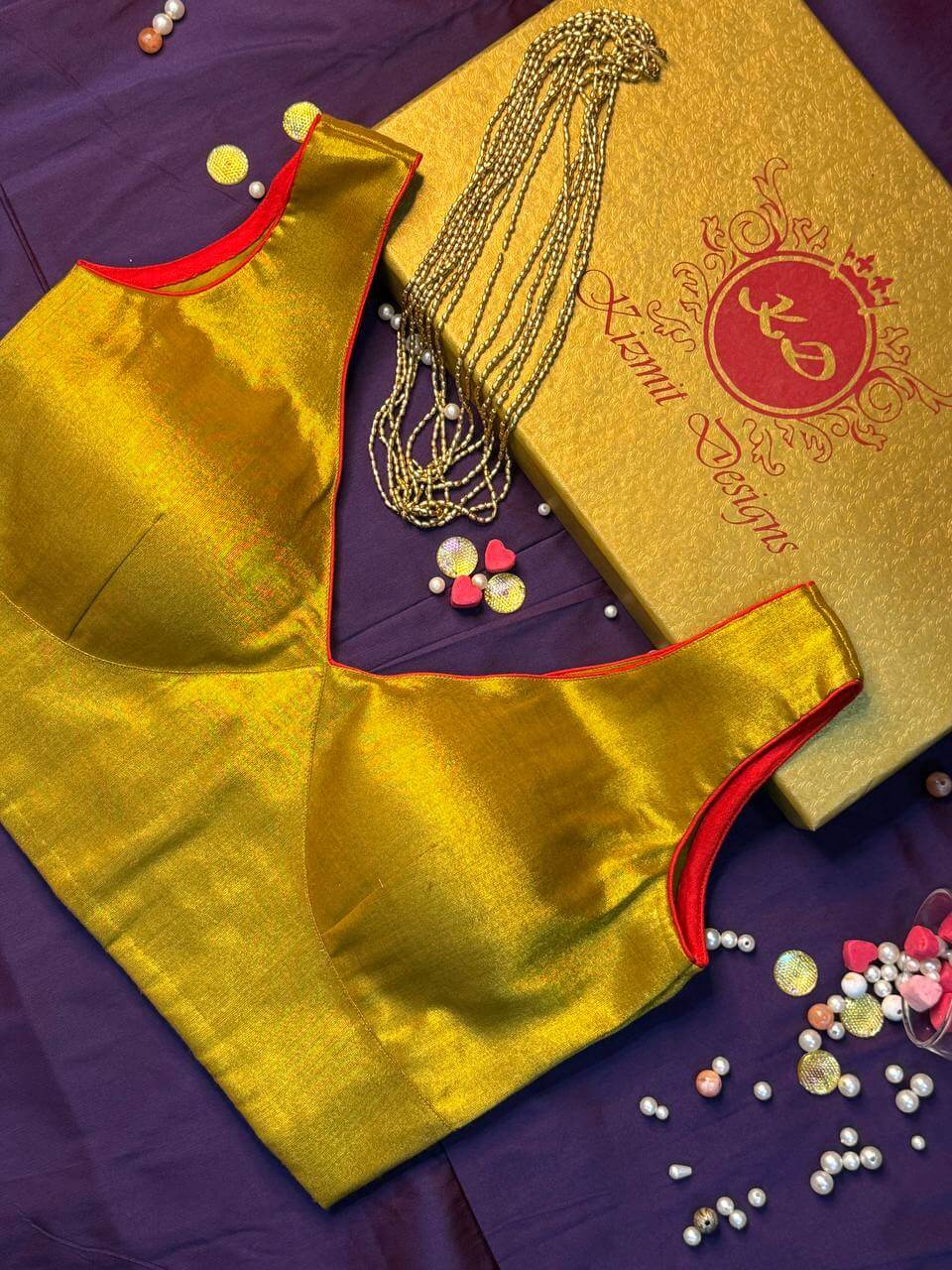 Shoulder line and red-edged armhole of the sleeveless gold blouse on purple cloth