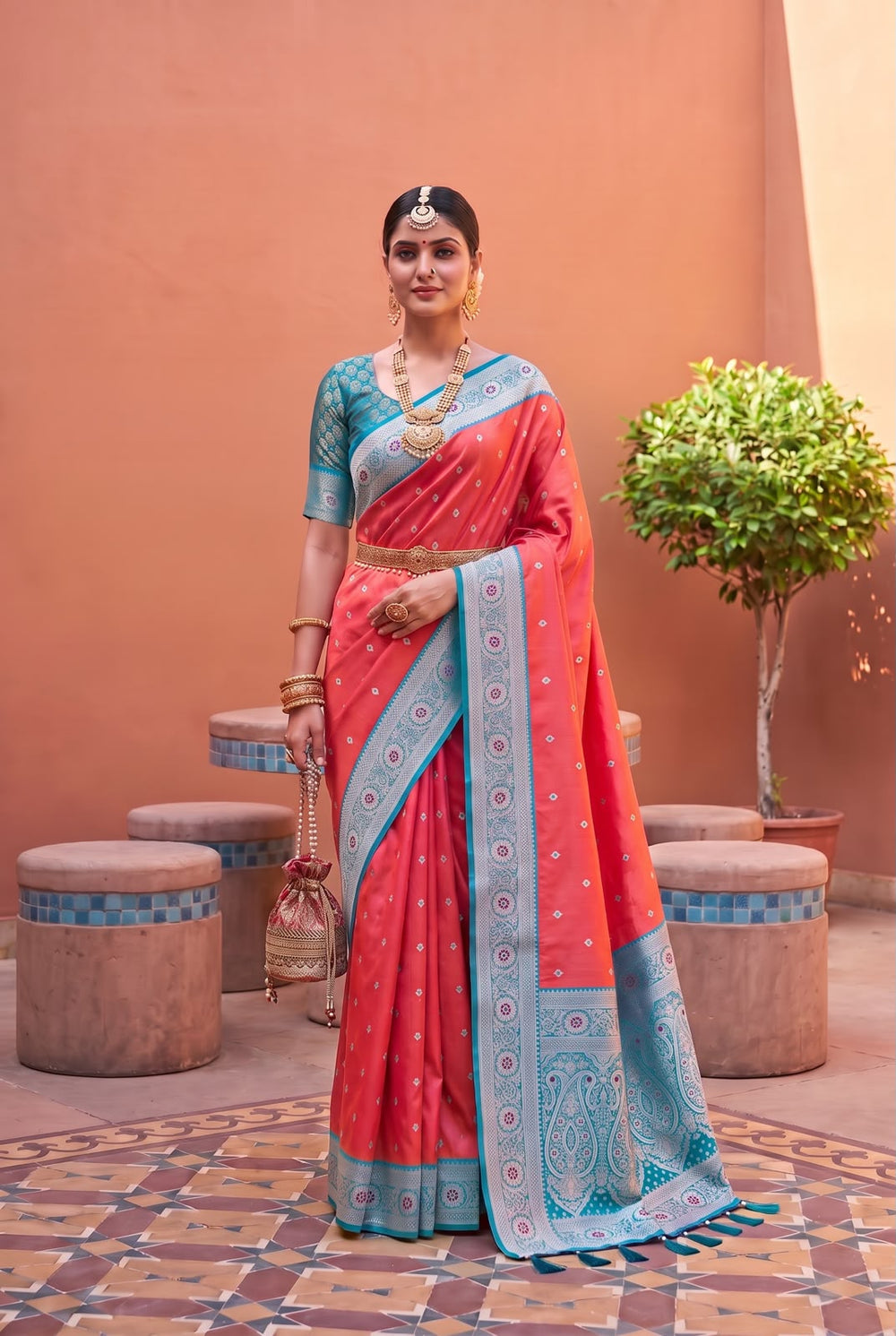 Model wearing the coral Banarasi Paithani saree with teal contrast border