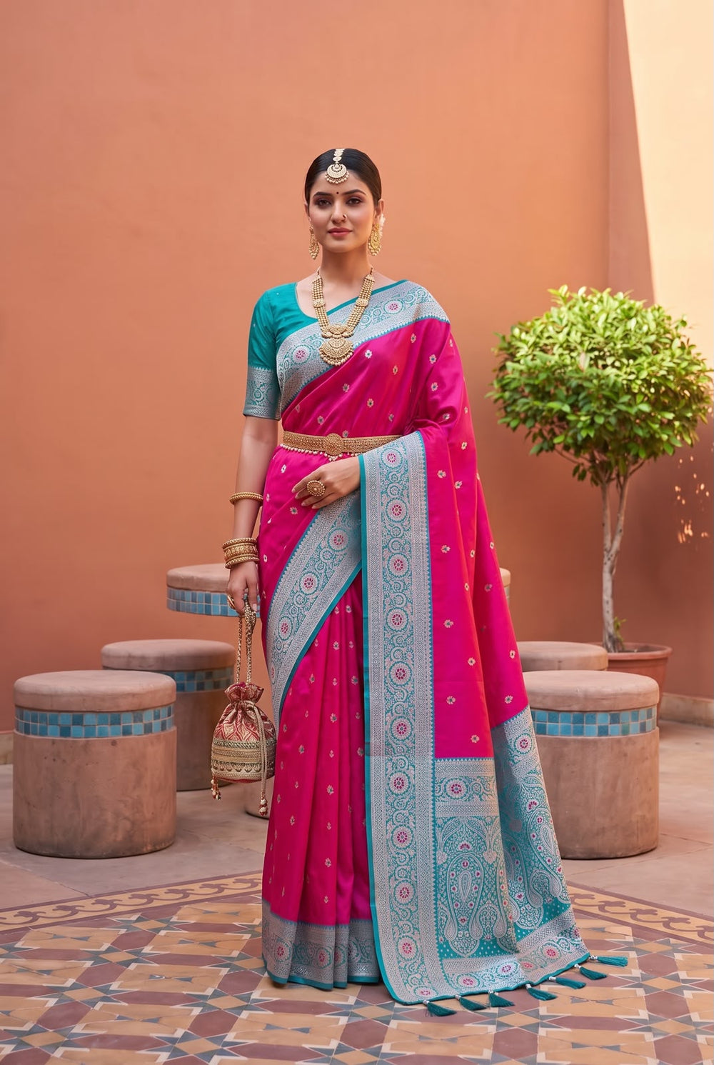Model wearing the rani pink Banarasi Paithani saree with teal contrast border