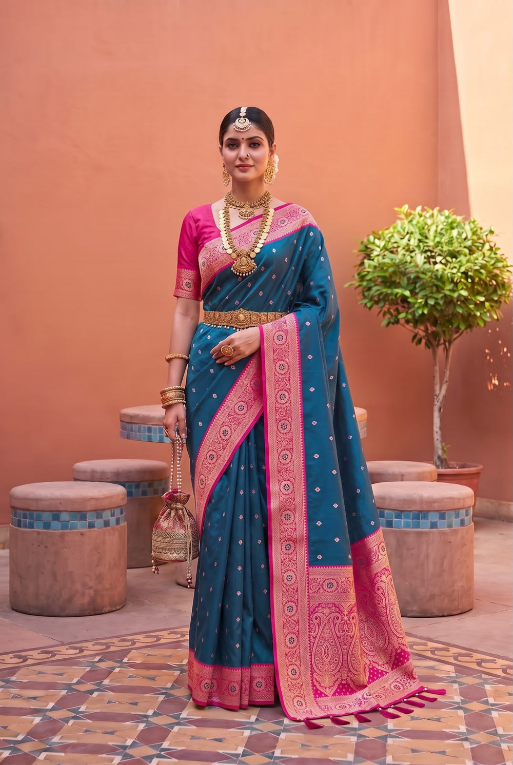 Model wearing the teal blue Banarasi Paithani saree with rani pink contrast border