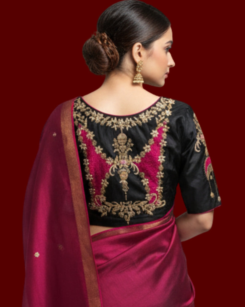 Model from behind in the black blouse, gold and pink embroidered back over a pink saree