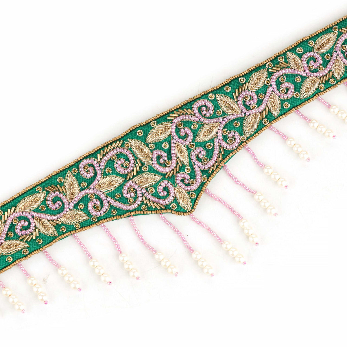 Close-up of gold zari and pink beadwork on the green saree belt above its pearl fringe