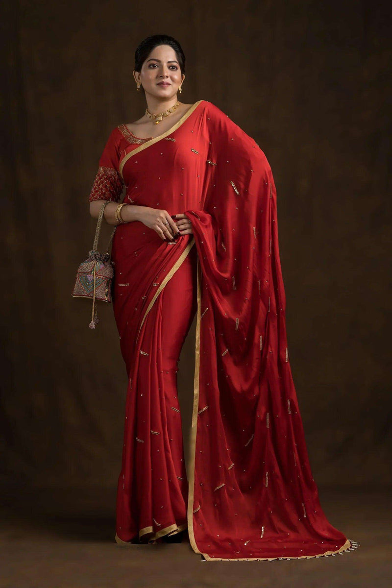 Model in a red saree wearing the crimson blouse, embroidered sleeve bands visible