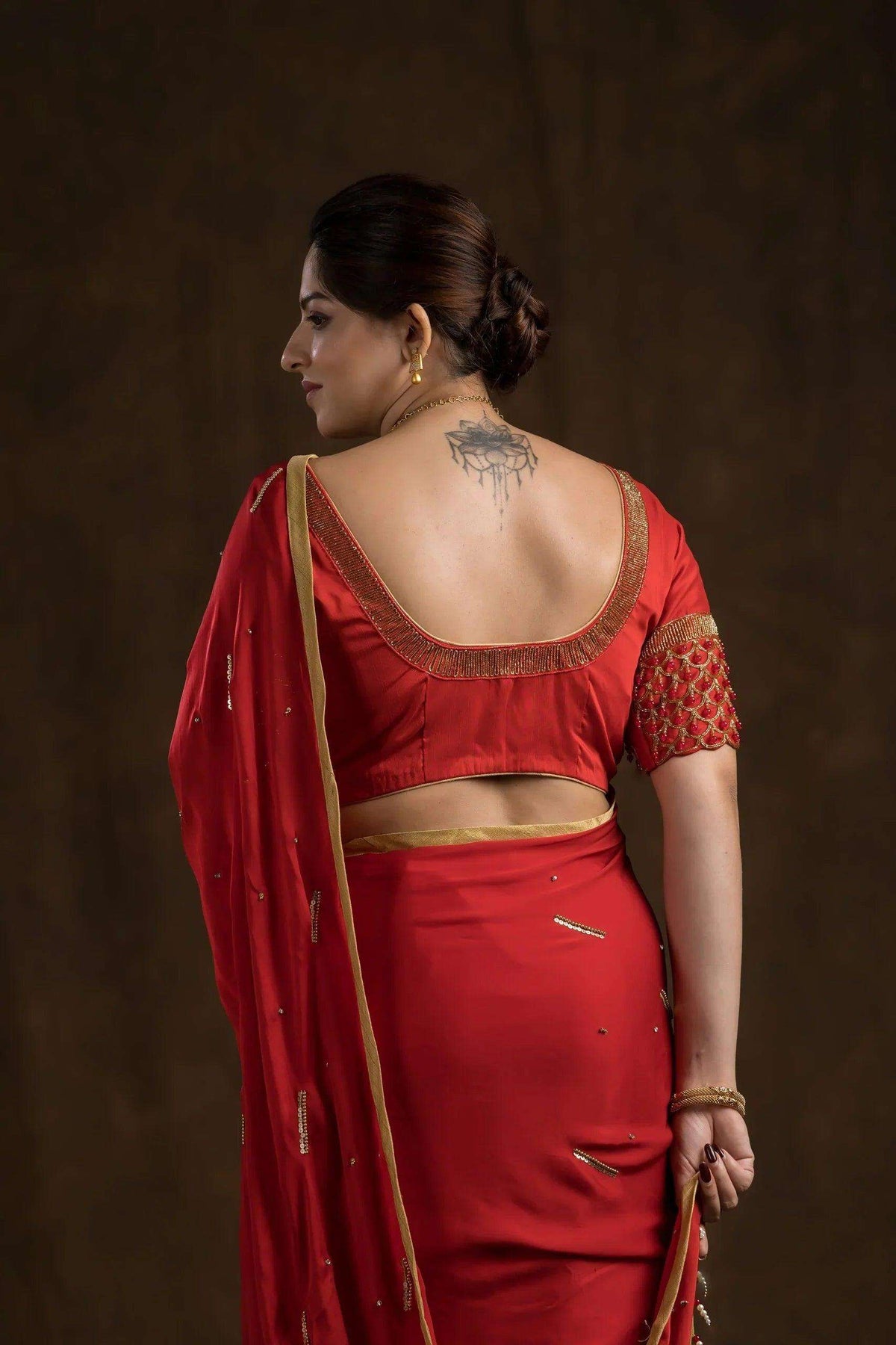 Close-up of the blouse back, gold-trimmed scoop neck and embroidered sleeve