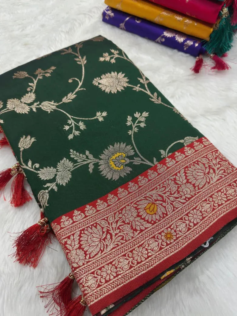 Bottle green saree folded flat showing gold zari flowers and a red brocade border