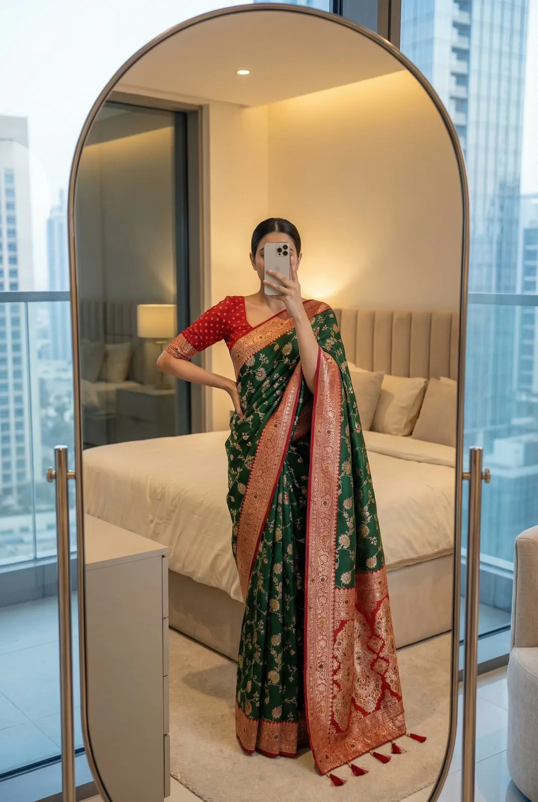 Bottle green soft silk saree with red border, worn with a red brocade blouse