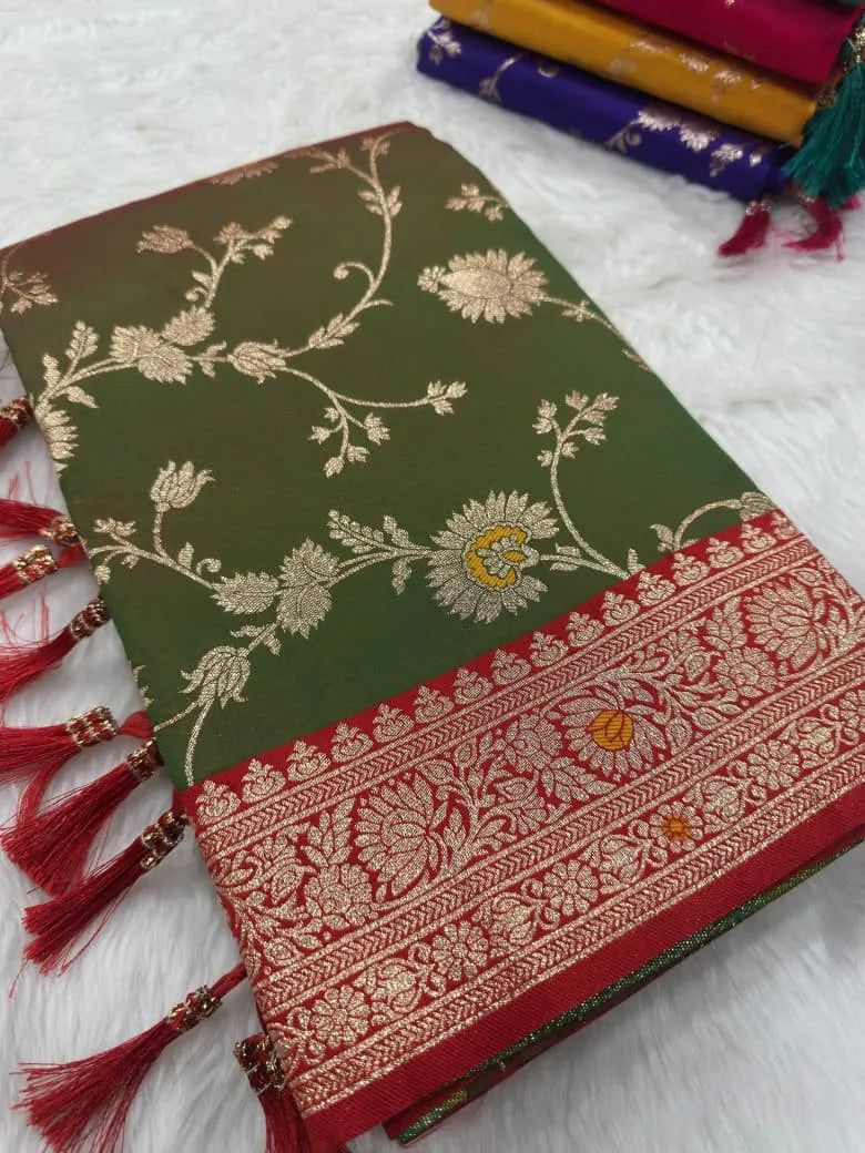 Folded mehendi green saree showing the gold zari jaal and red brocade border up close
