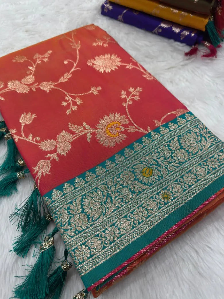 Coral orange saree folded flat, gold zari jaal beside a teal brocade border with tassels