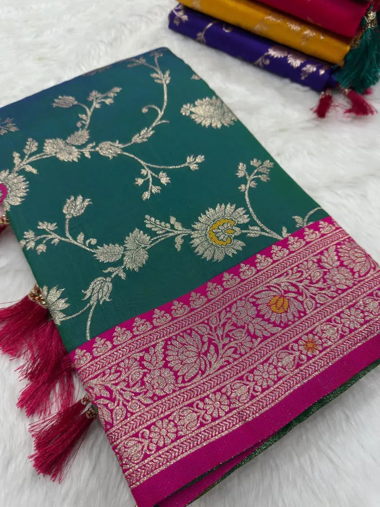 Peacock teal saree folded to show the zari lotus jaal against a rani pink brocade border
