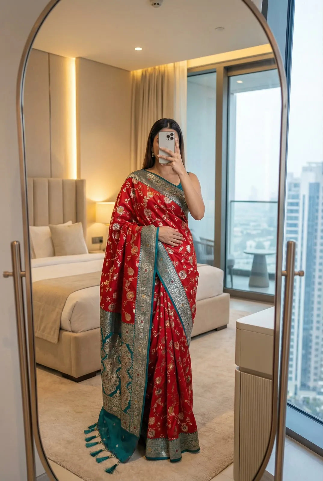 Red soft silk saree with teal green contrast border, draped with tasselled pallu in front