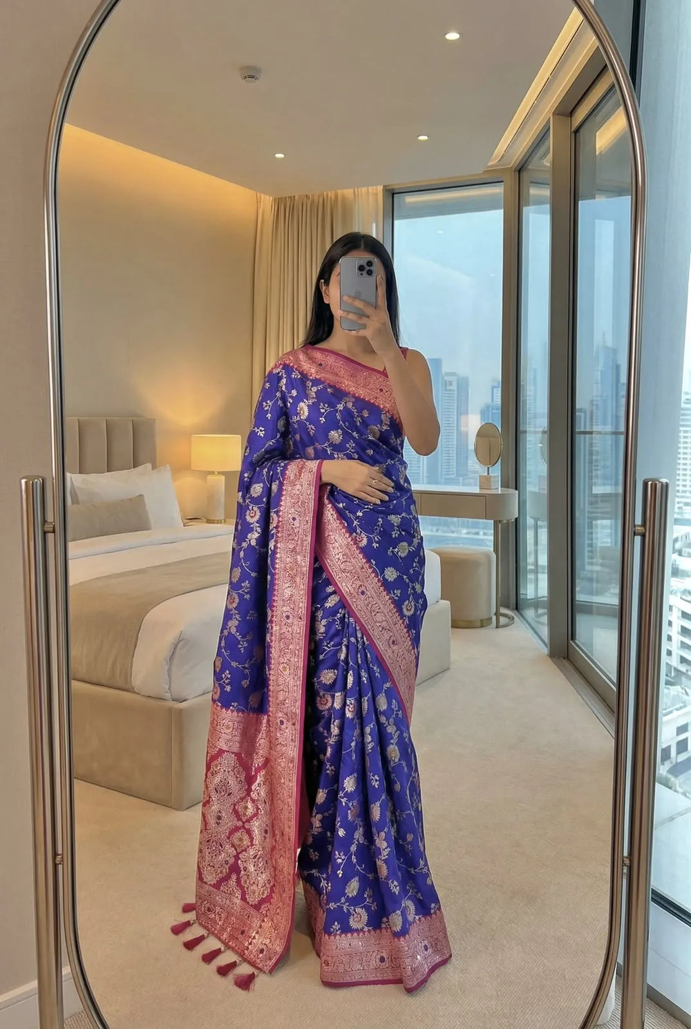 Royal blue soft silk saree with pink zari border, draped full length with the pallu over one shoulder