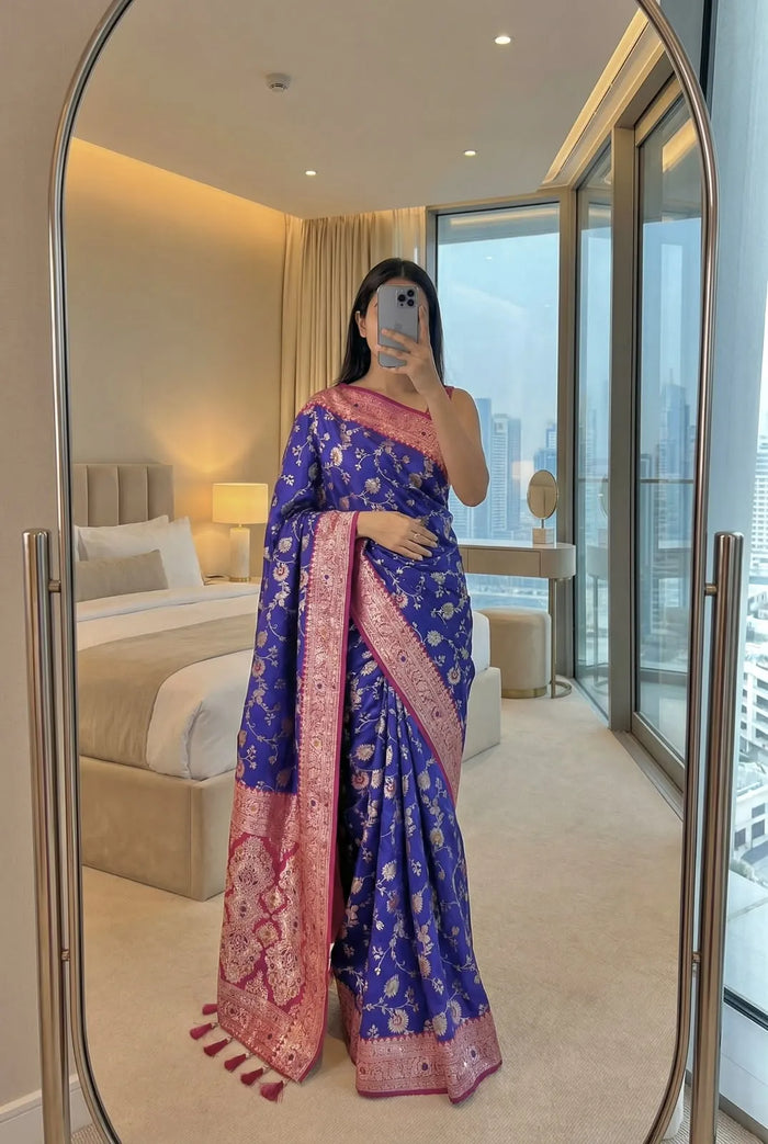 Royal blue soft silk saree with pink zari border, draped full length with the pallu over one shoulder