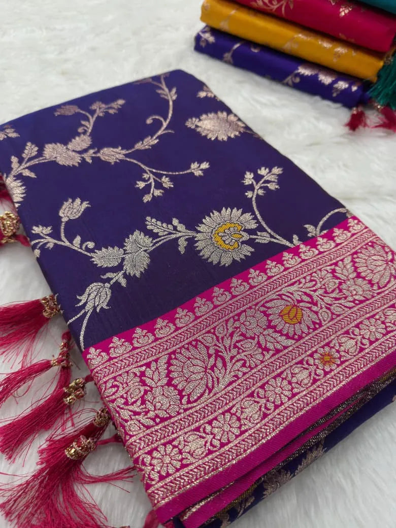 Violet saree folded flat, silver-gold floral jaal against a rani pink brocade border