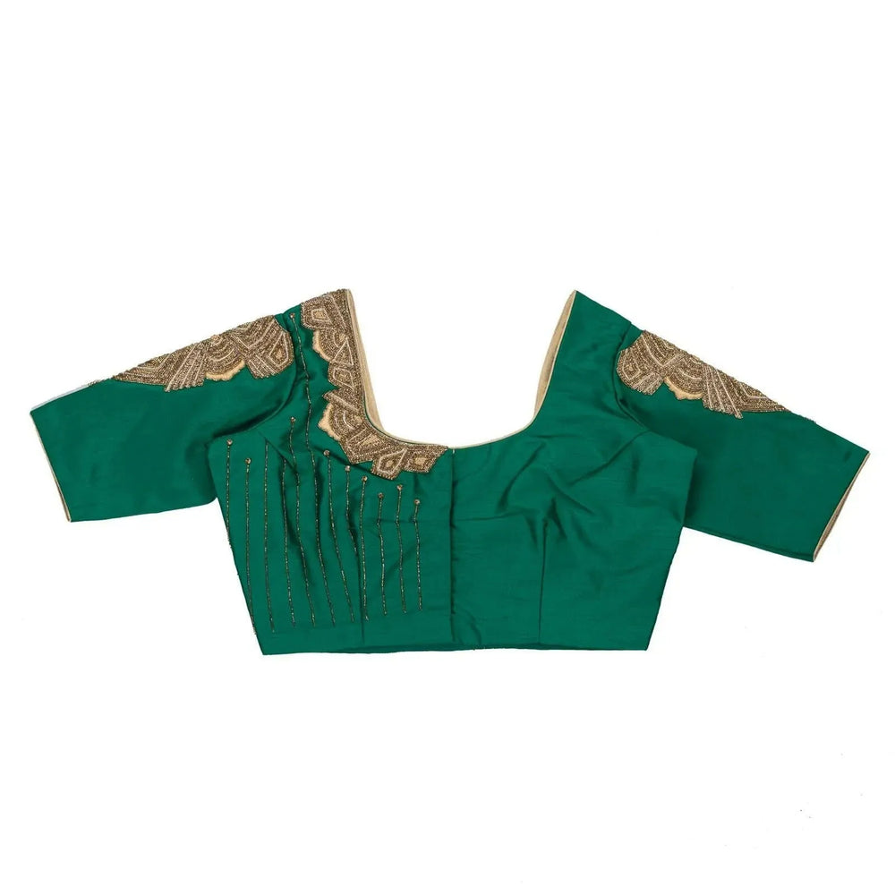 Green blouse laid flat front up, gold beadwork fanning down from the neckline