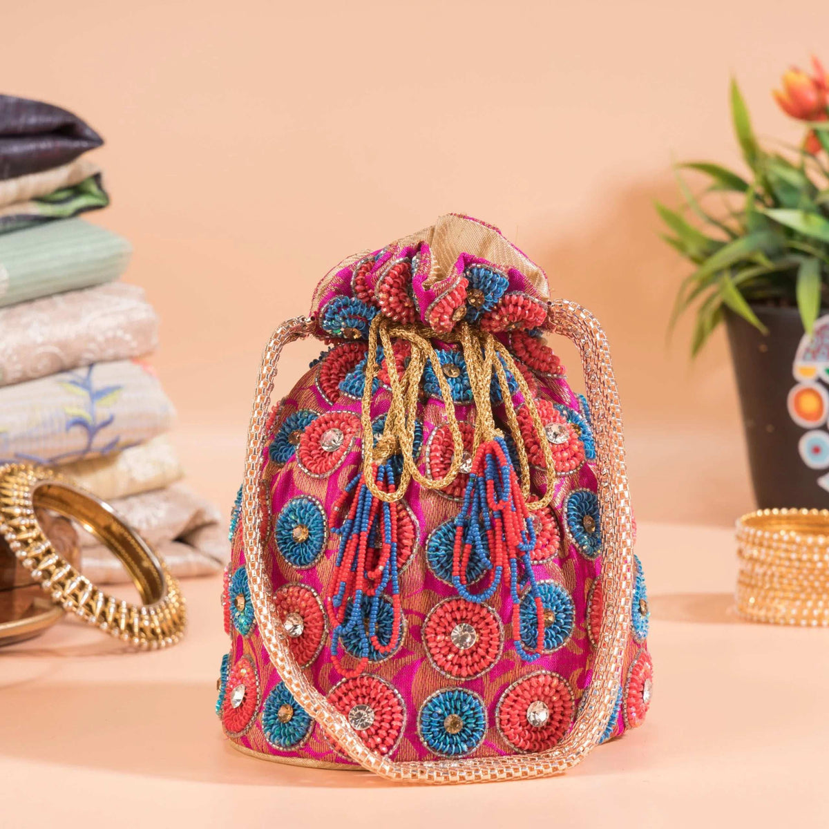 Gathered drawstring top of the spiral-motif potli with beaded cords and tassels