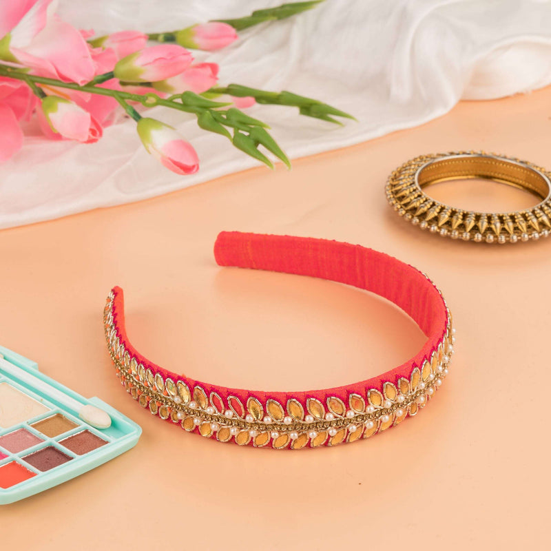 Coral pink headband with gold leaf stones styled with tulips and a bangle on peach