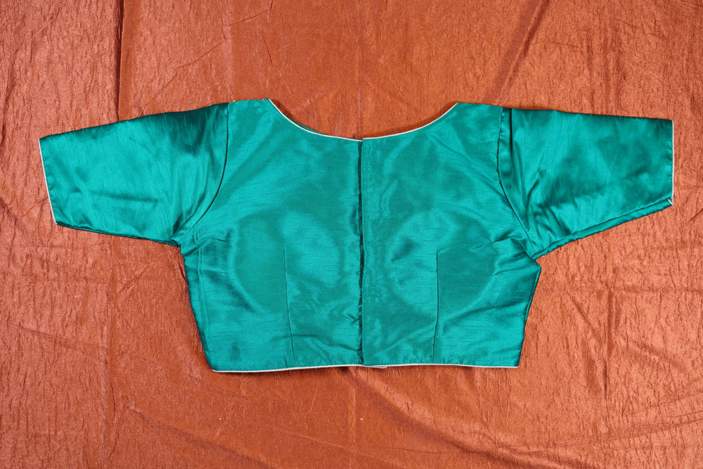 Back of the green blouse in plain silk with centre back opening, laid flat