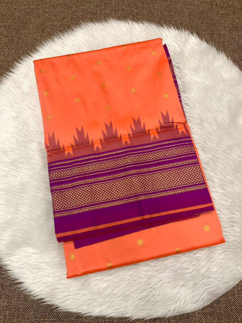 Ilkal silk saree in coral orange with a purple temple border and gold buttis