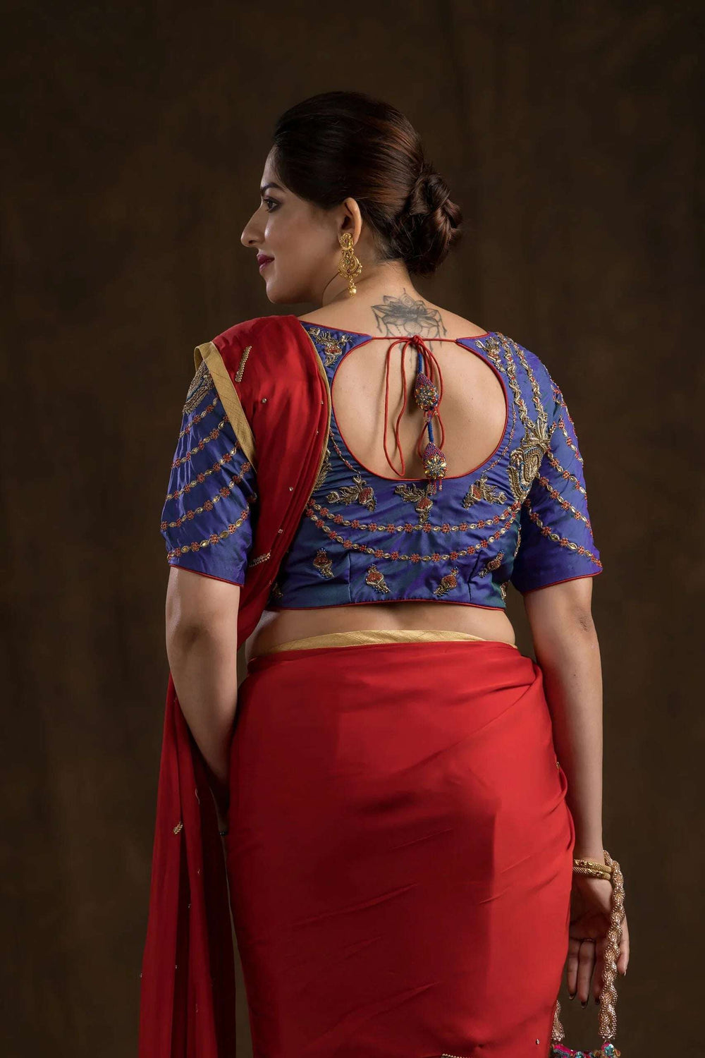 Keyhole back of the blouse with red dori tie, Mughal floral motifs in gold across the yoke