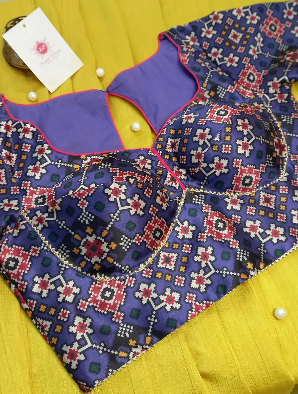 Gold bead outlining the cup seams of the patola printed blouse, seen from above
