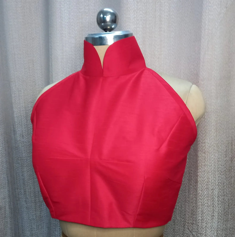 Front view on a bust form, red halter blouse with a stand collar and notched neckline