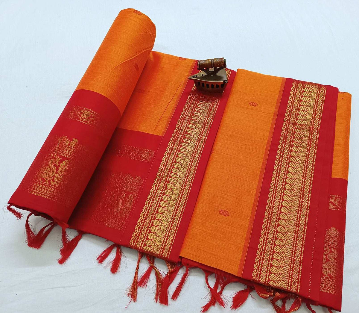 Orange Latika Gadwal saree with red zari border and tasselled pallu, flat lay