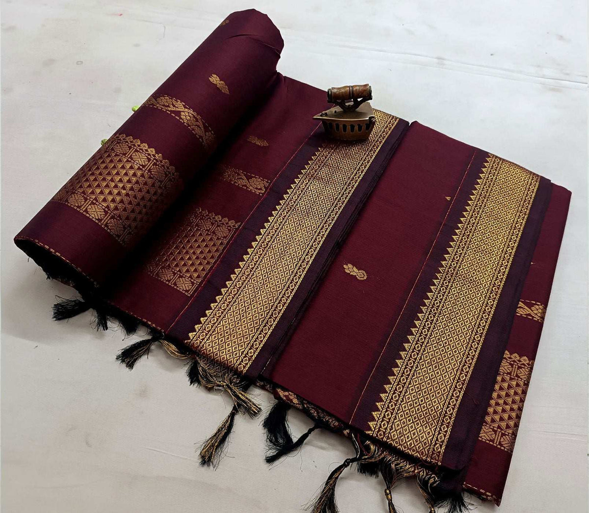Wine maroon saree in a single tone, gold zari border and booti detail