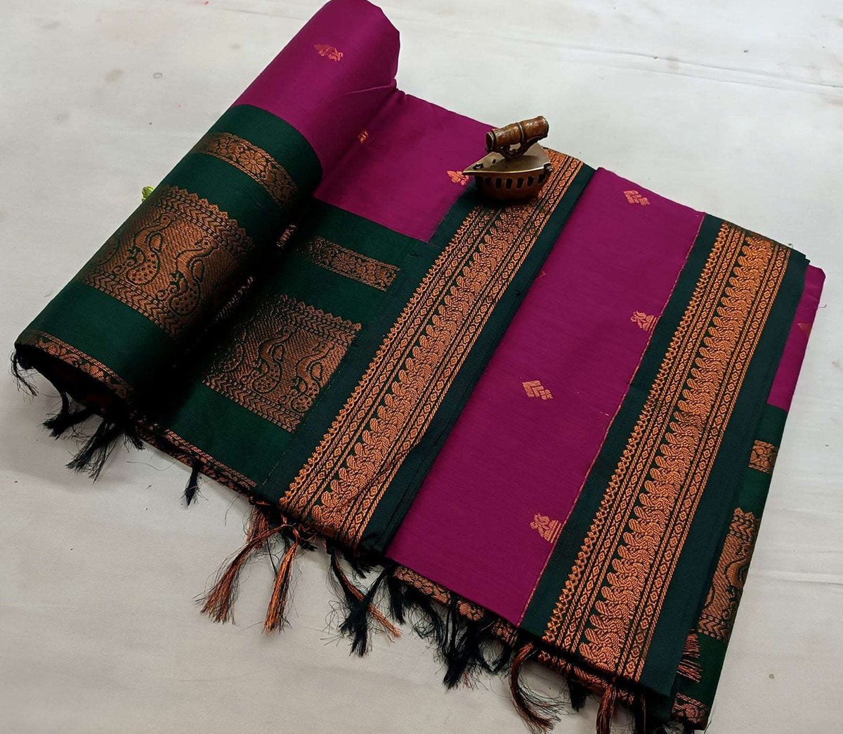 Magenta saree with bottle green border, copper zari pallu folded alongside