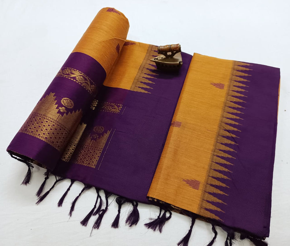 Mustard body edged with a purple temple-tip border, pallu rolled alongside the flat drape