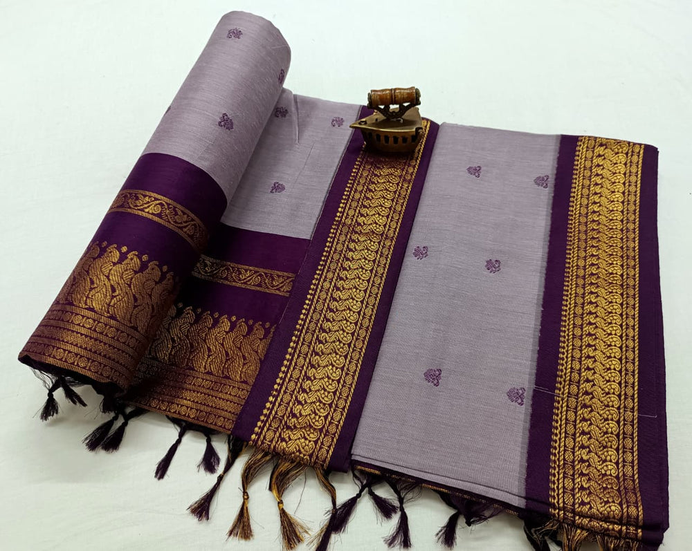 Lavender saree with deep purple and gold zari border, small bootis scattered on the body