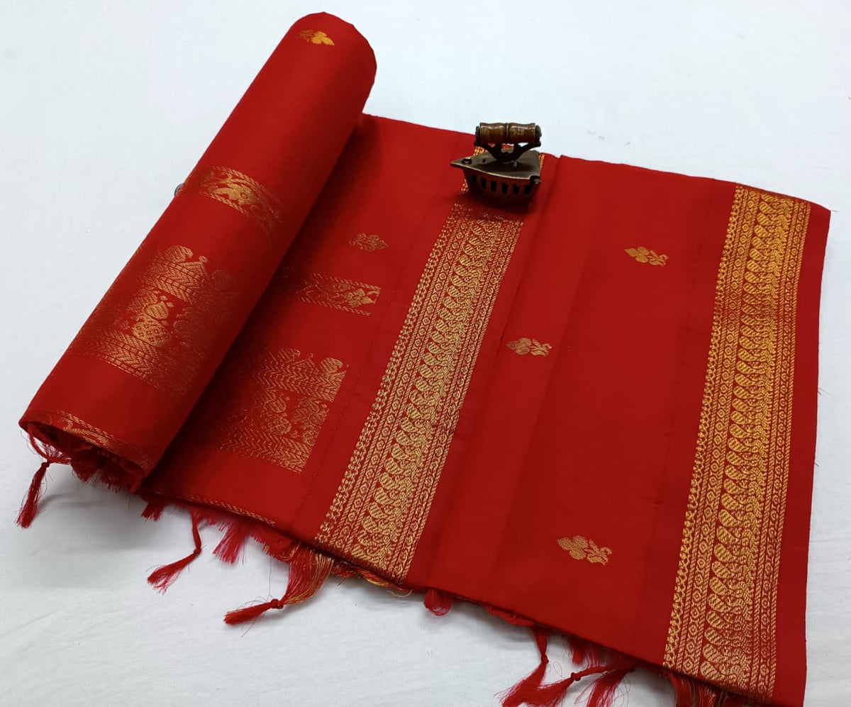 Red-on-red Latika saree with gold zari bootis and a woven border, laid flat with the pallu rolled