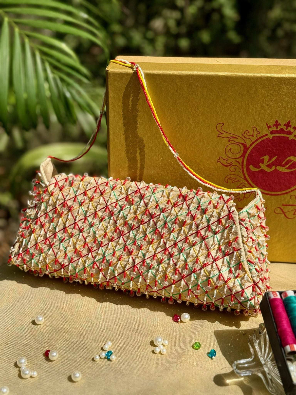 Clutch seen at an angle, cream flap worked in criss-cross thread lattice with bead trim