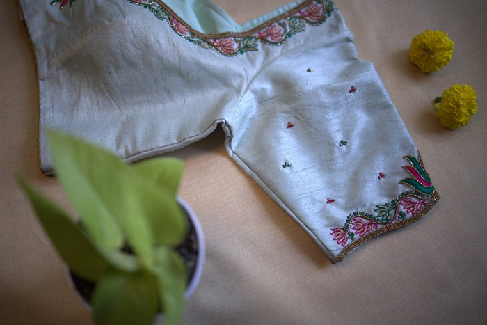 Blouse laid at an angle, sleeve hem lotus border and scattered bootis in view