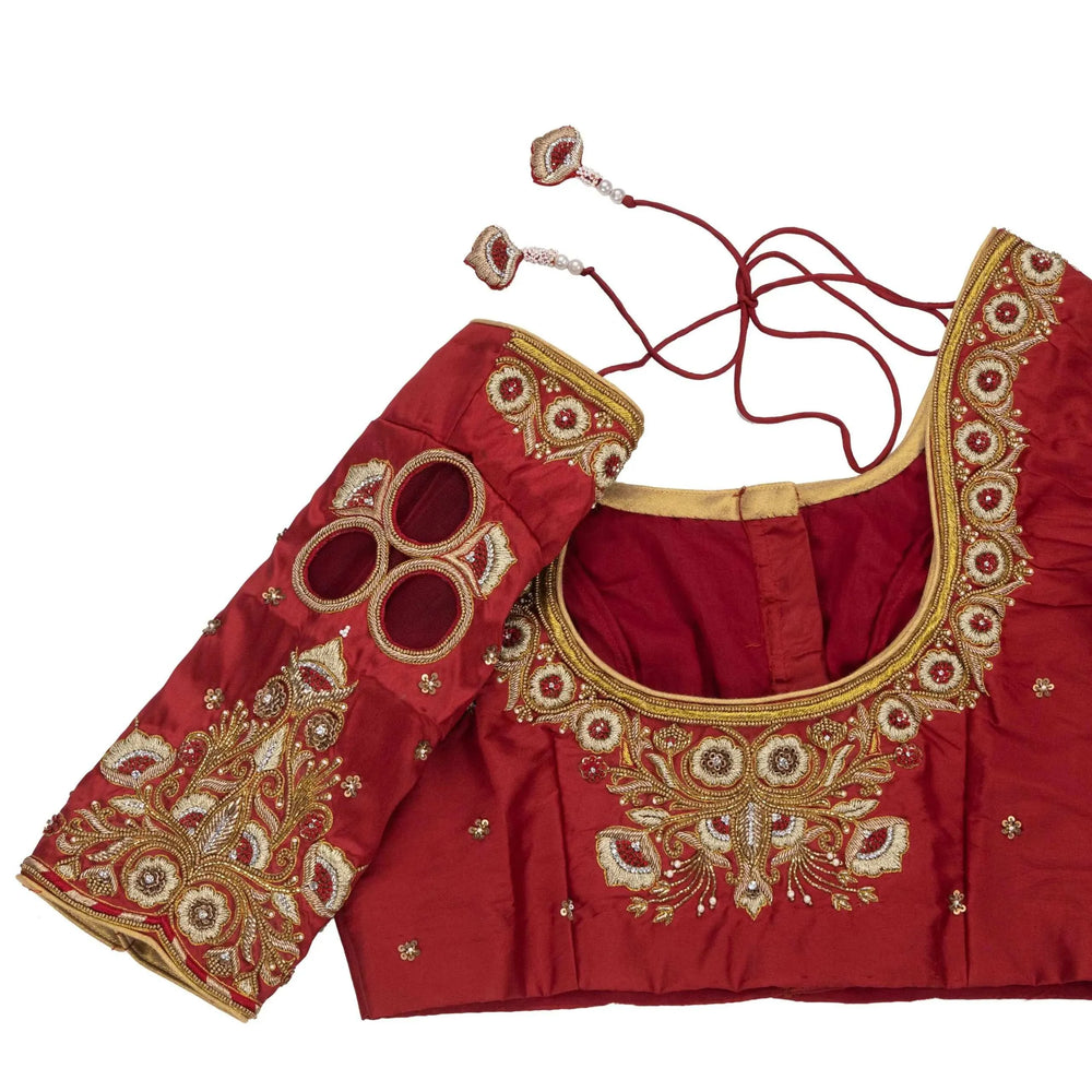 Close-up of mirror discs and gold zardozi on the sleeve, with maroon dori tassels