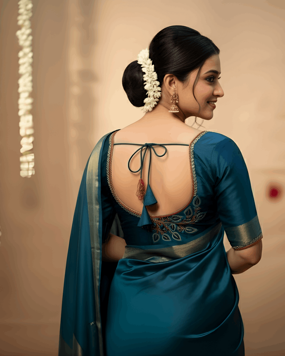 Model in teal with the deep back blouse tied by a dori, feather embroidery at the shoulder