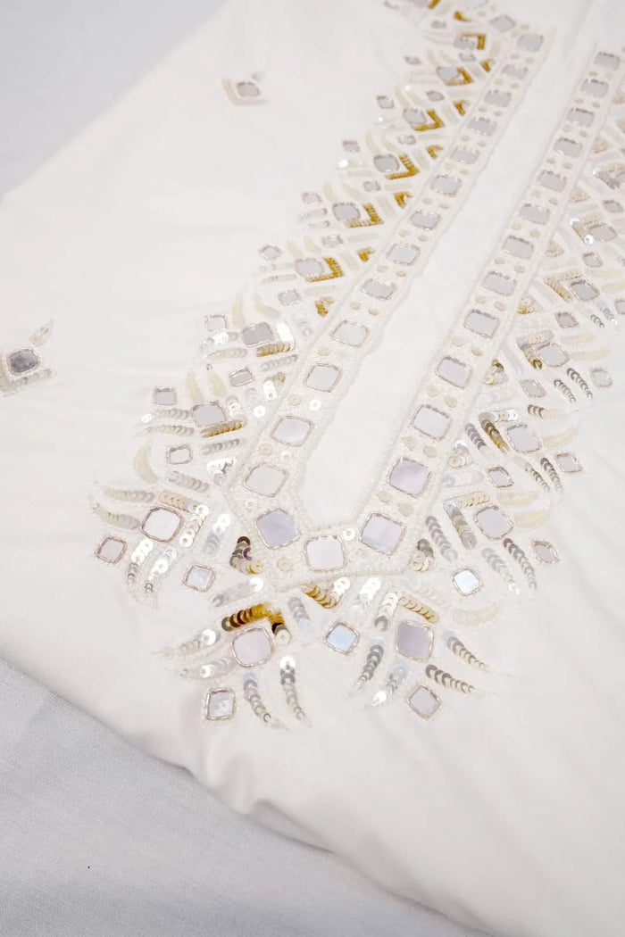 Mirror-work neckline panel on the off-white kurta fabric, angled close-up