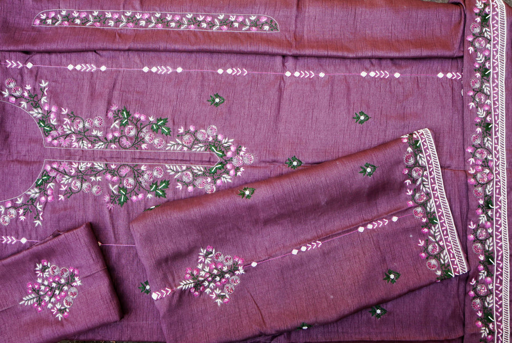 Overhead view of the folded unstitched set with the embroidered dupatta border