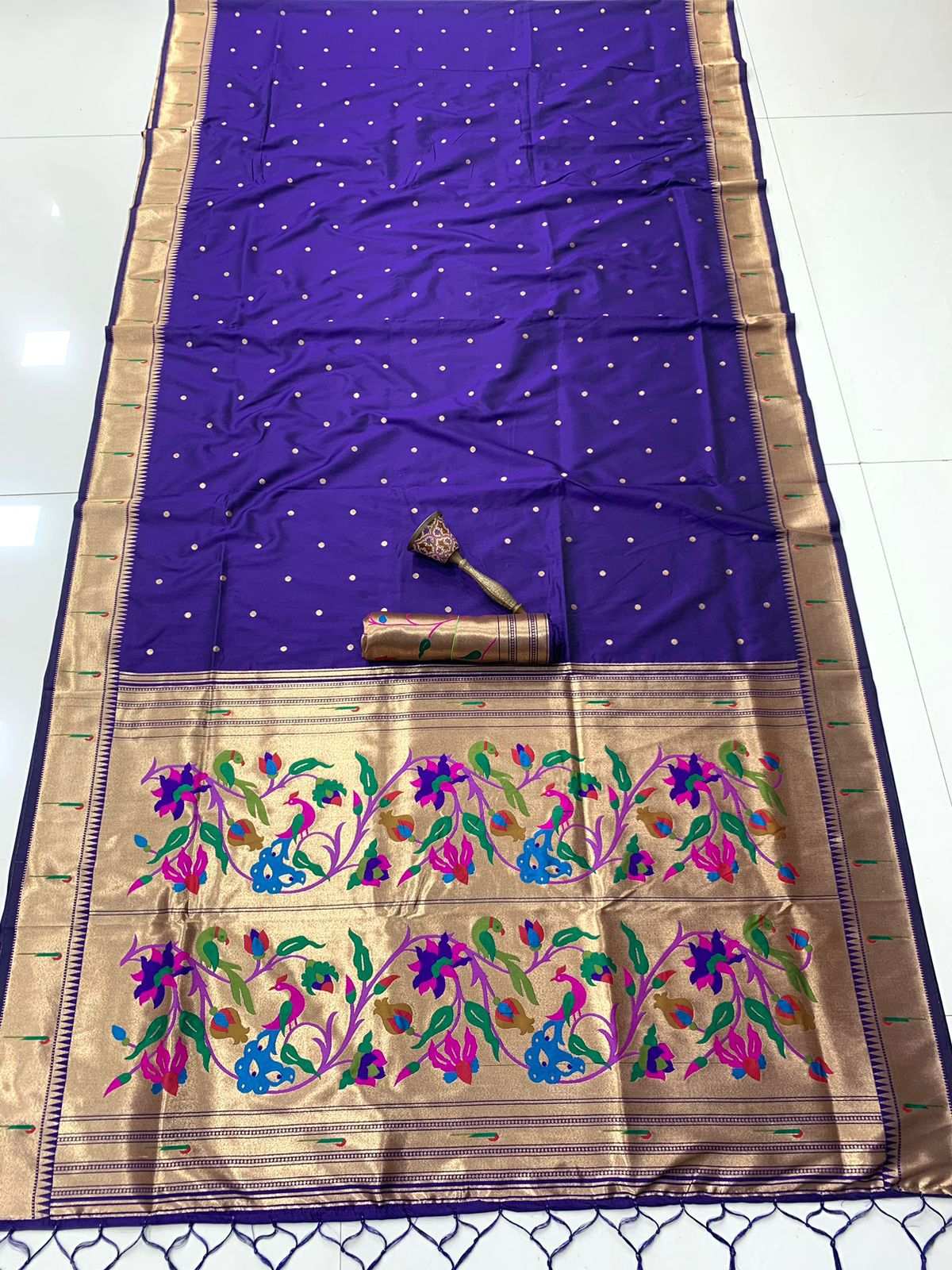 Deep violet Paithani saree flat-laid, meenakari floral pallu in gold zari at the lower end