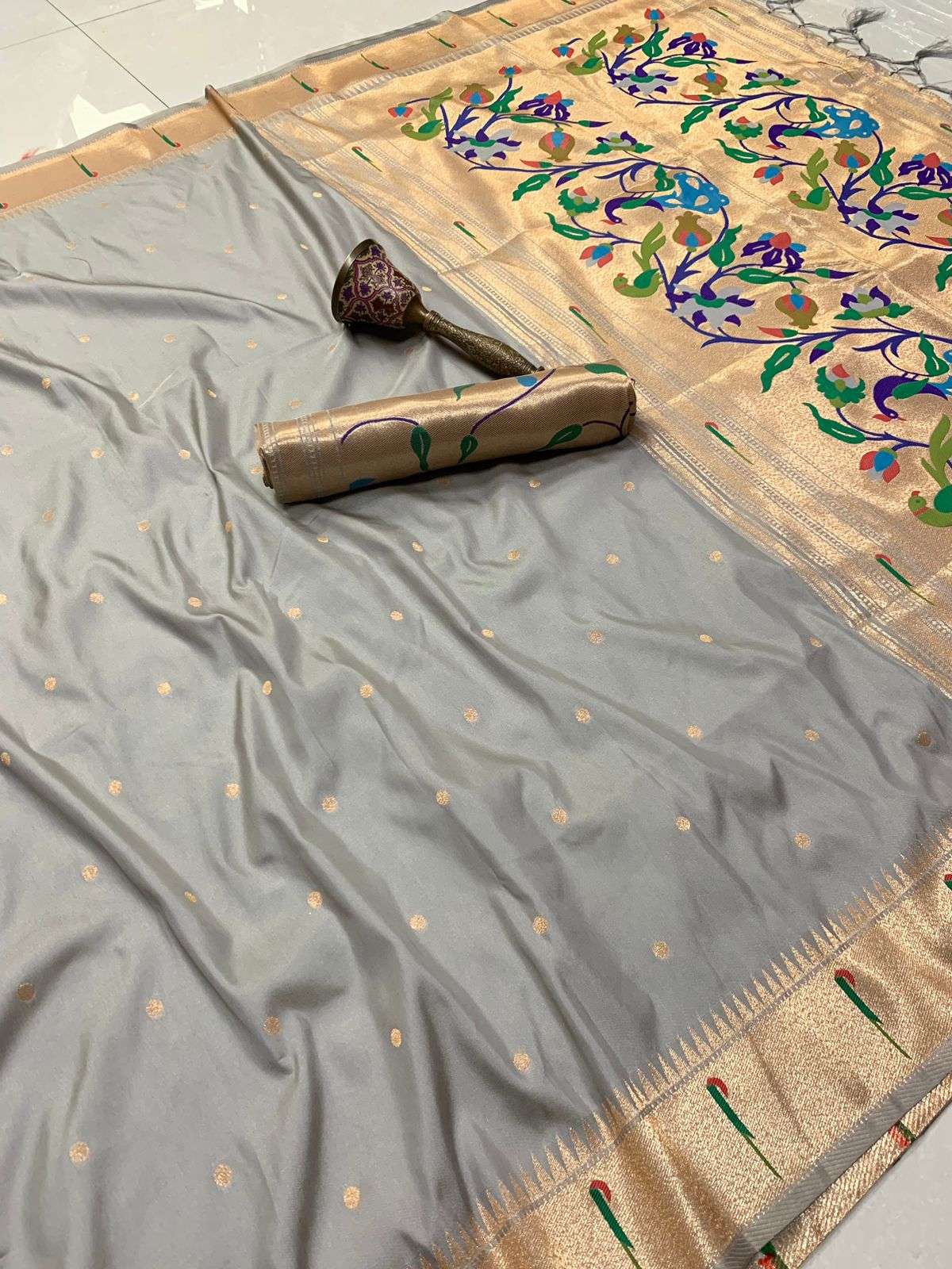 Grey Paithani saree with gold zari bootis and a colourful floral pallu across the top
