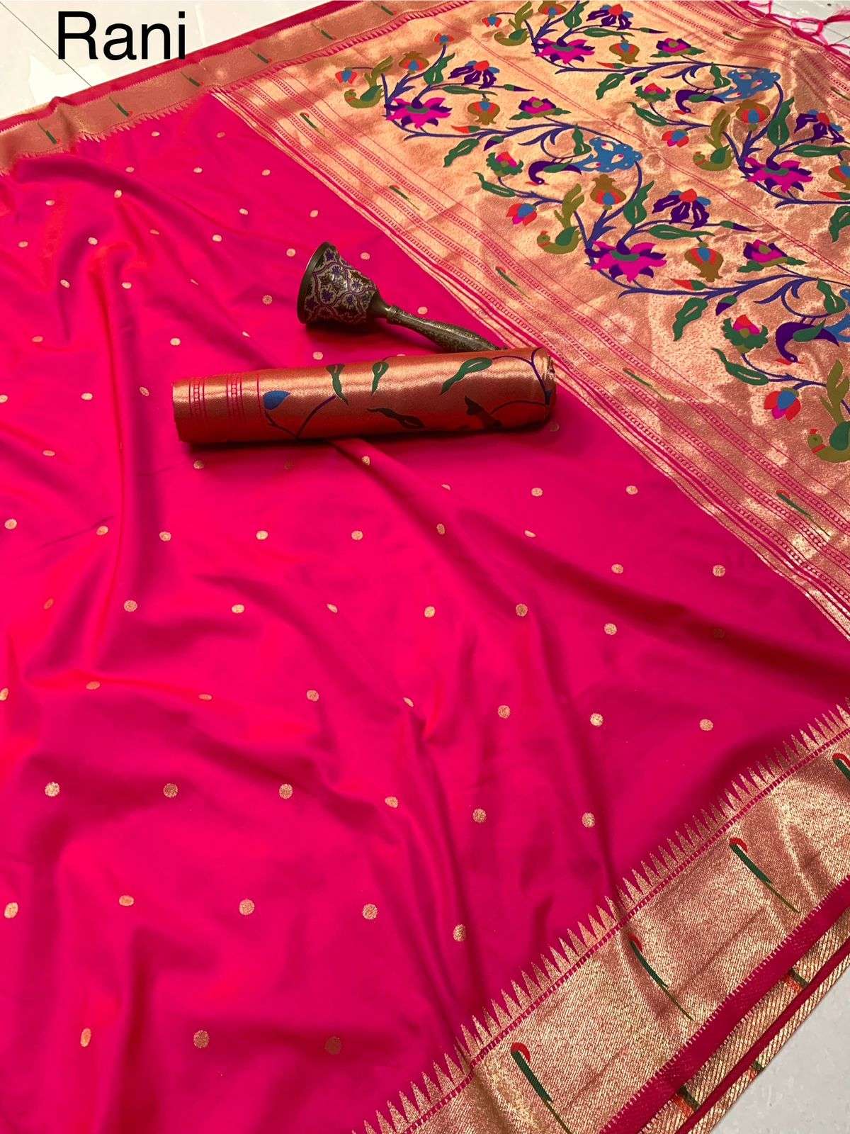 Rani pink Paithani saree with gold bootis, shade name labelled above the rolled blouse piece