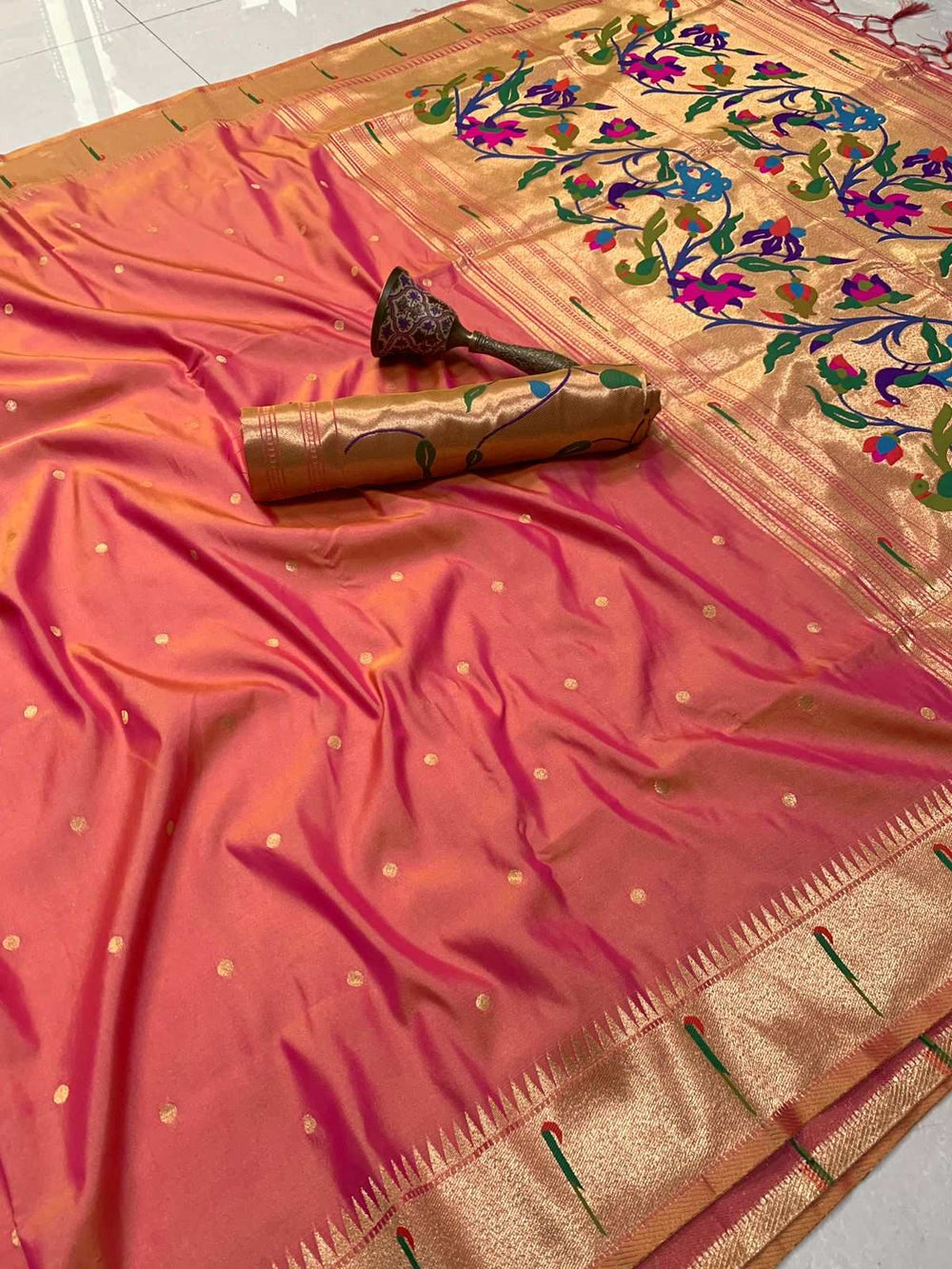 Peach Paithani saree with zari bootis and peacock motif pallu folded behind the blouse piece