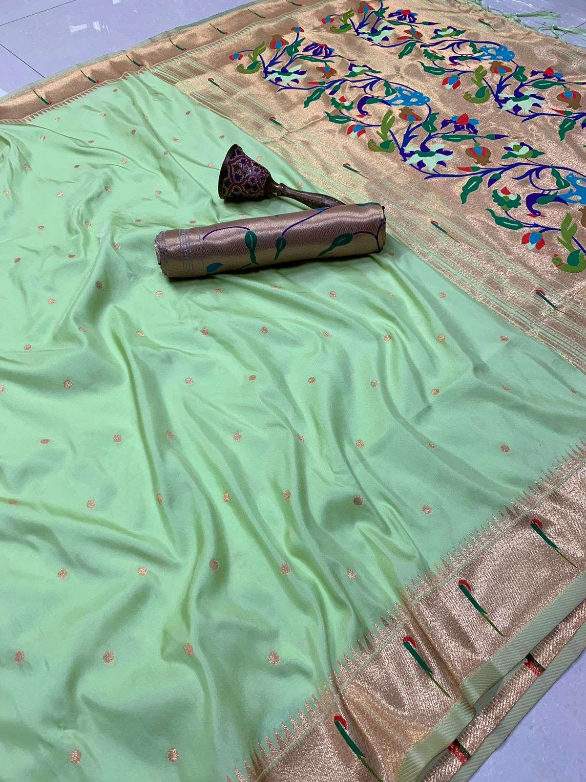 Pista green Paithani saree with fine zari bootis and floral zari pallu spread behind