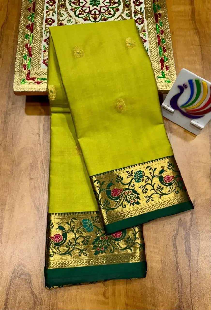 Lime green Paithani saree folded, dark green border with gold peacock and vine motifs